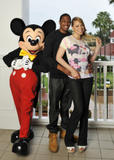Mariah Carey and and Nick Cannon posing with Mickey Mouse 